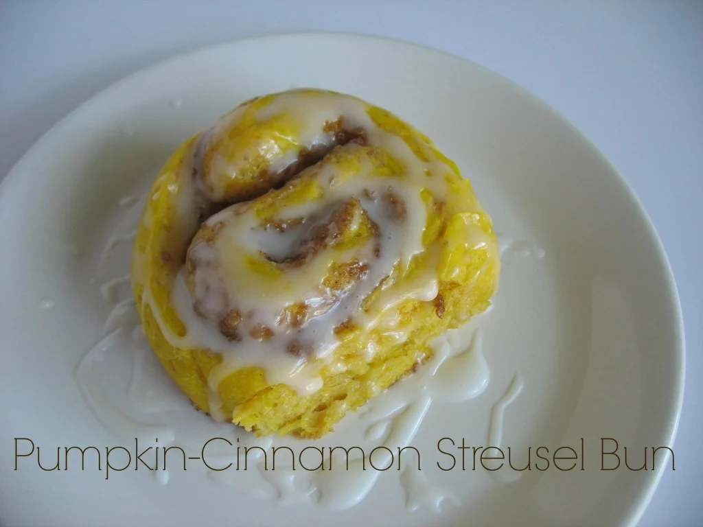 A Pumpkin Cinnamon Streusel Bun on a white plate