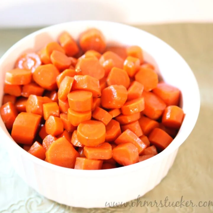 Bright orange cooked carrots in a white bowl, perfect for healthy side dishes.