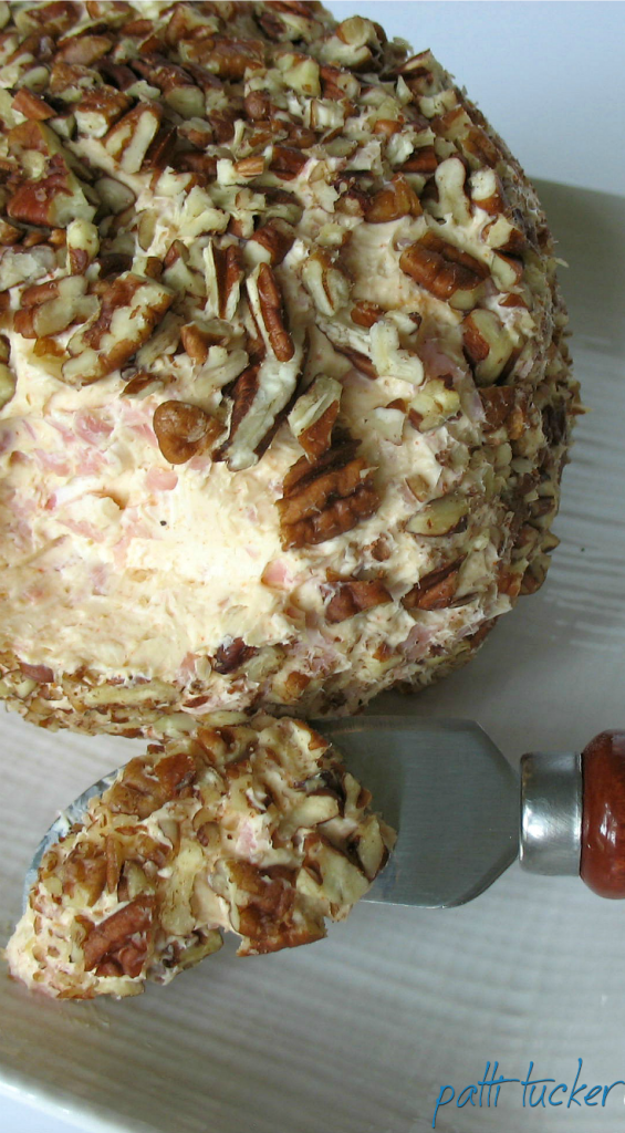 cheese ball on plate with a smear on knife