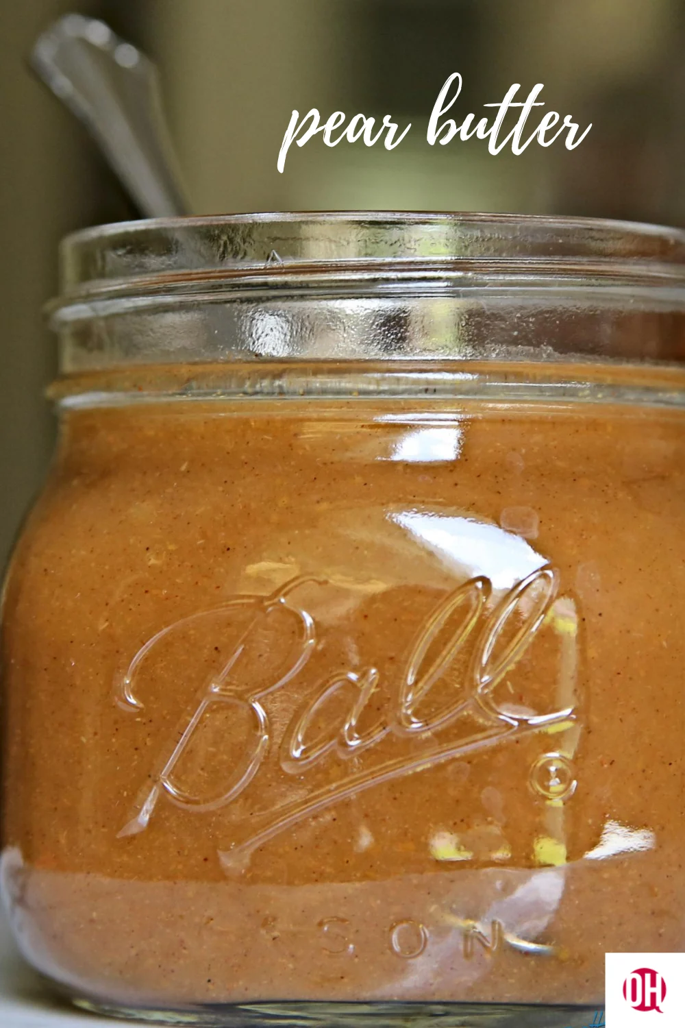 pear butter in a jar with a spoon