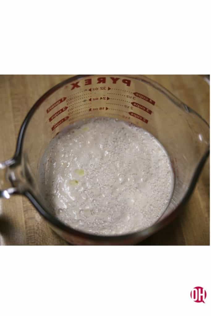 Proofed bubbling yeast in a measuring cup
