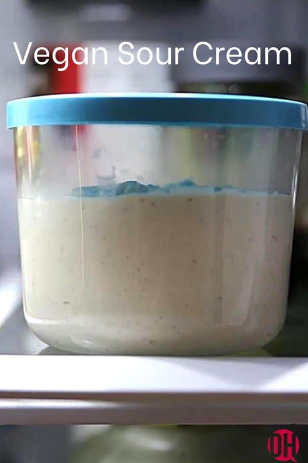 a glass dish with a blue lid with vegan sour cream in it