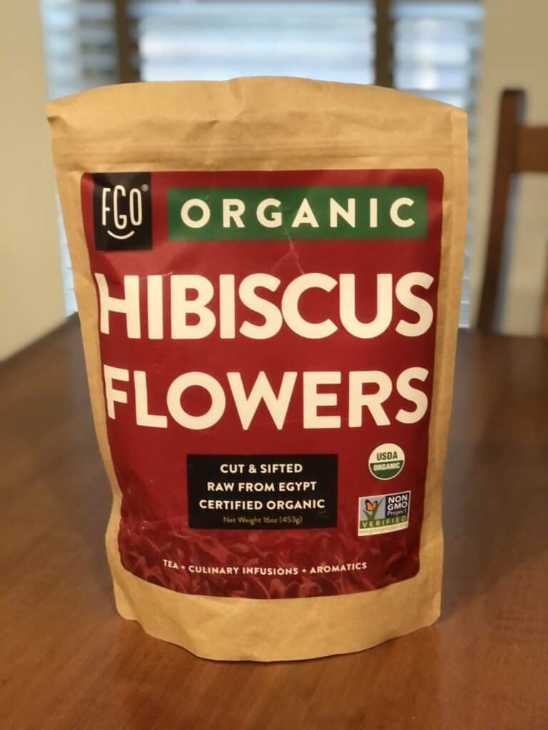 Bag of FGO organic hibiscus flowers on a wooden table