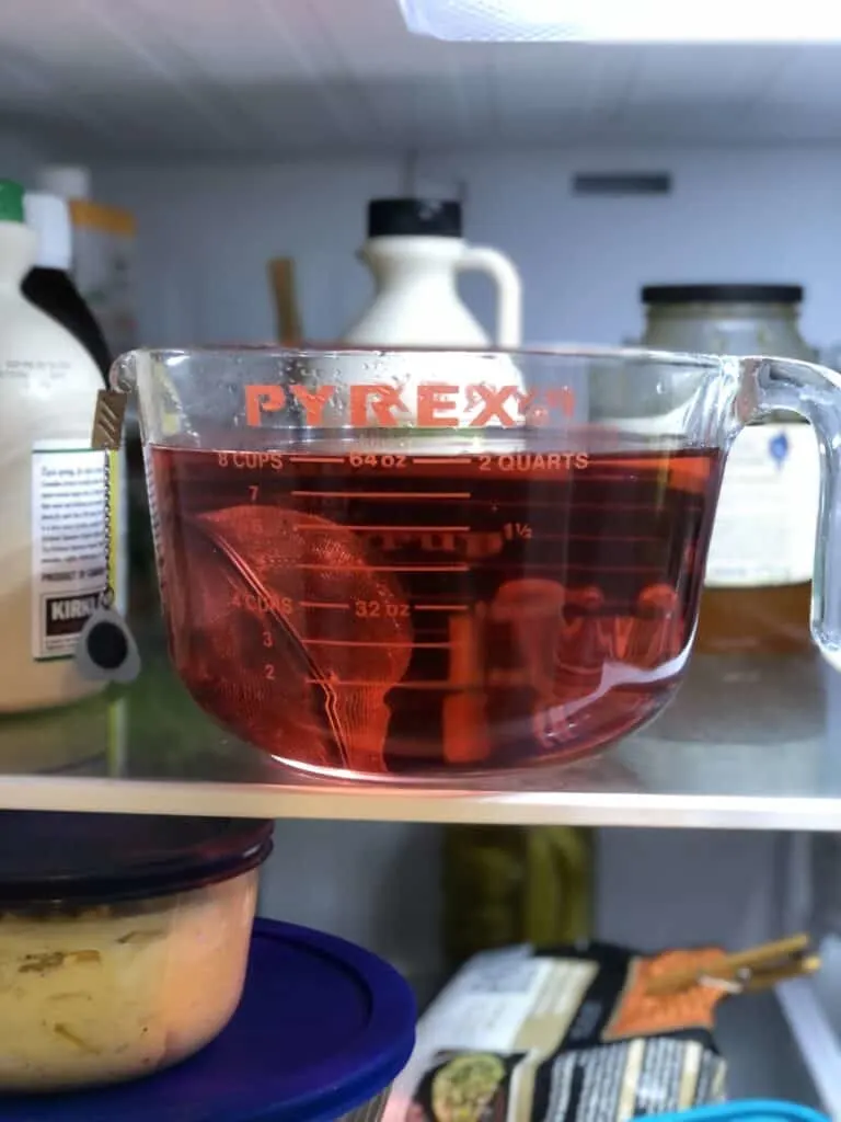 pyrex measuring cup with hibiscus tea brewing in fridge