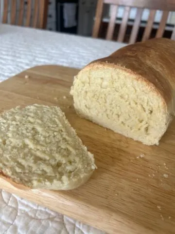Homemade Sandwich Bread with a slice cut, placed on cutting board