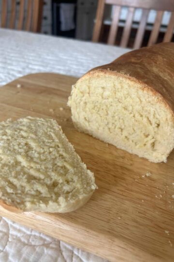 Homemade Sandwich Bread with a slice cut, placed on cutting board