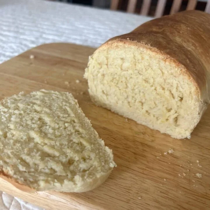 Homemade Sandwich Bread with a slice cut, placed on cutting board